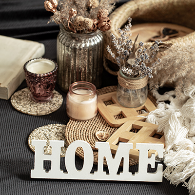 Still life with home decor items, candles and a vase with dried flowers, wooden inscription home. The concept of home comfort.